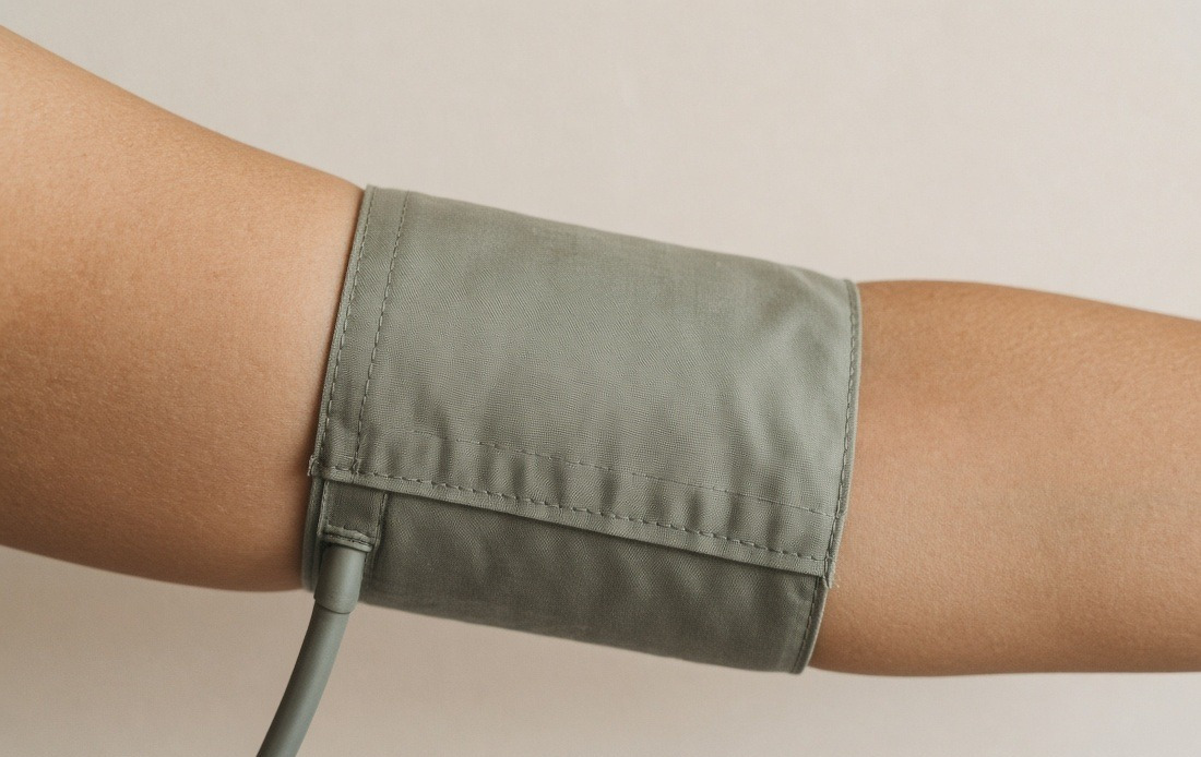 A blood pressure cuff fastened around an upper arm
